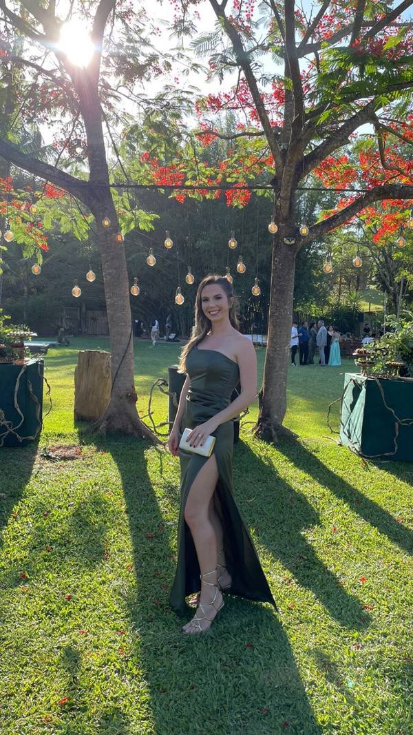 Vestido longo verde oliva em tecido acetinado, decote de um ombro só, modelagem reta e fenda lateral profunda.