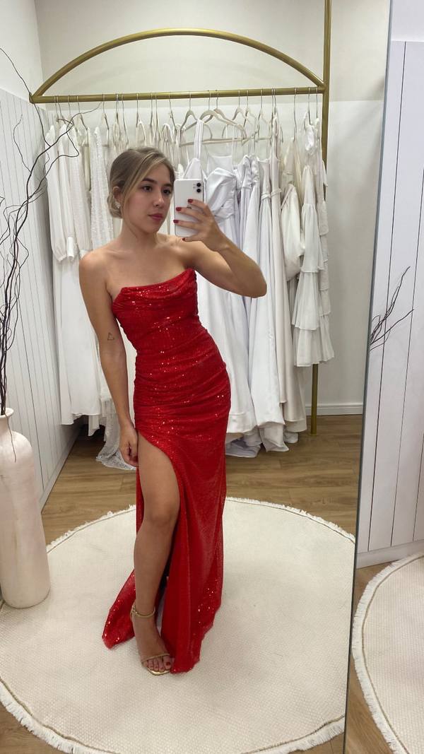 Vestido longo vermelho com paetês, modelagem justa, decote tomara que caia e fenda lateral na saia.