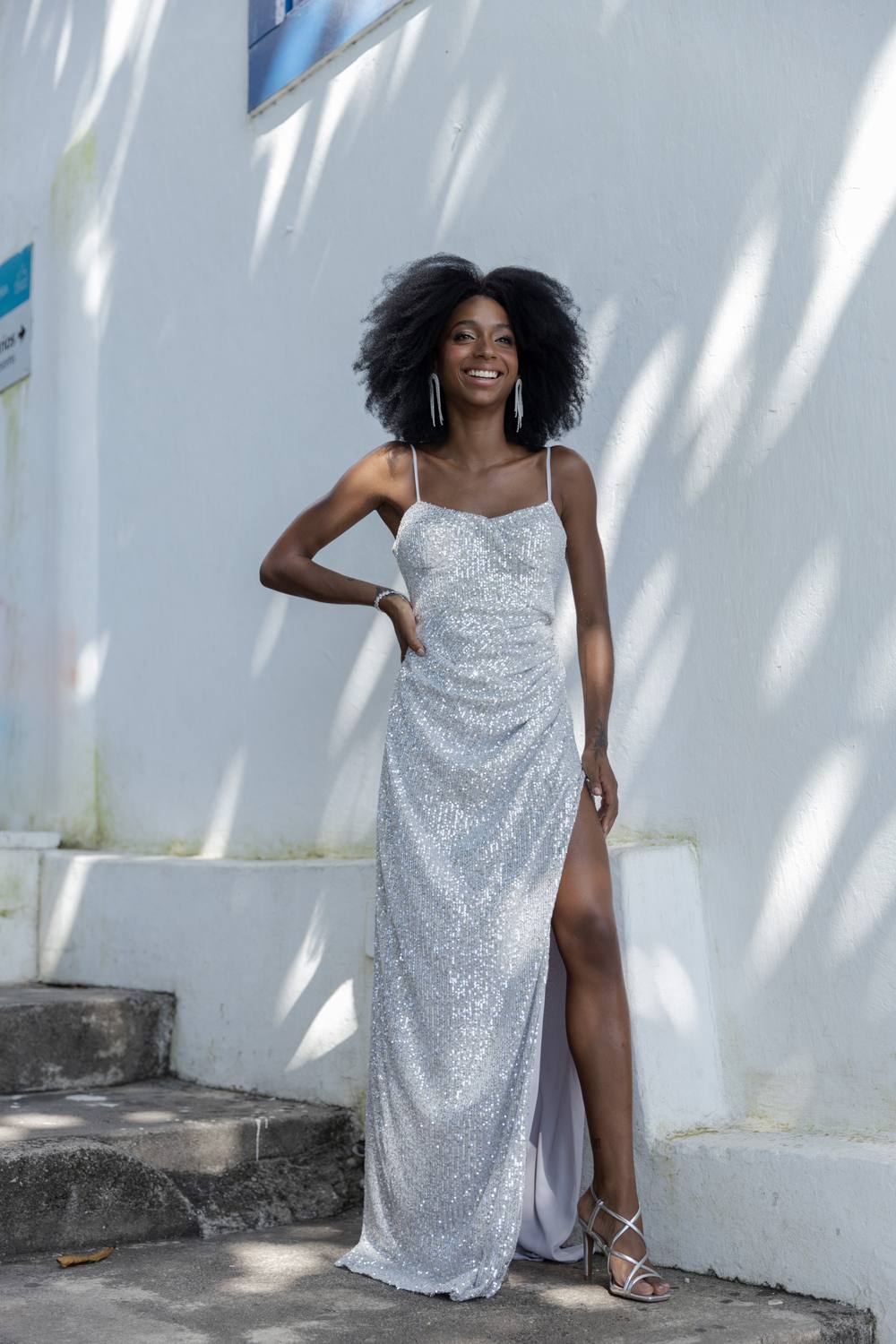 Vestido longo prata de paetê com brilho, alças finas, fenda lateral e corte reto.