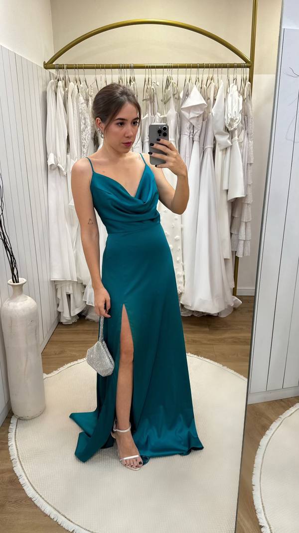 Vestido longo verde petróleo em cetim, com alças finas, decote degagê, fenda frontal e saia fluida.