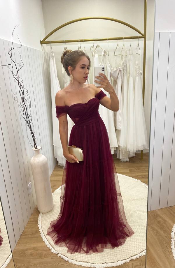 Vestido longo na cor marsala em tule, com decote ombro a ombro drapeado e saia fluida em camadas.