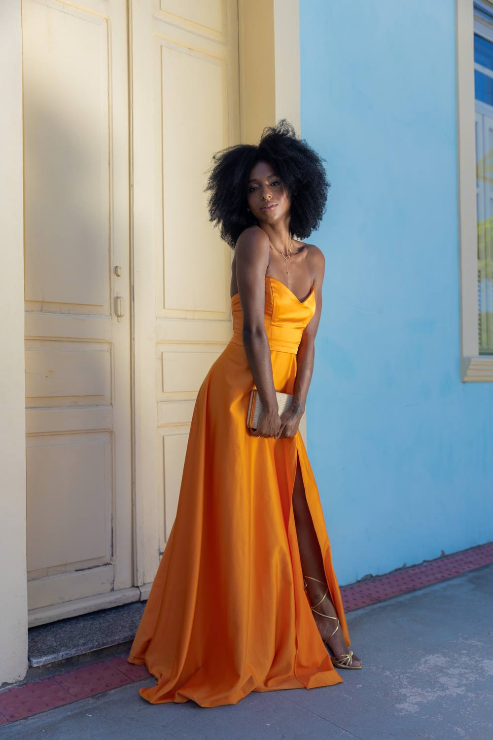 Vestido longo laranja tomara que caia, com saia evasê fluida e fenda lateral.