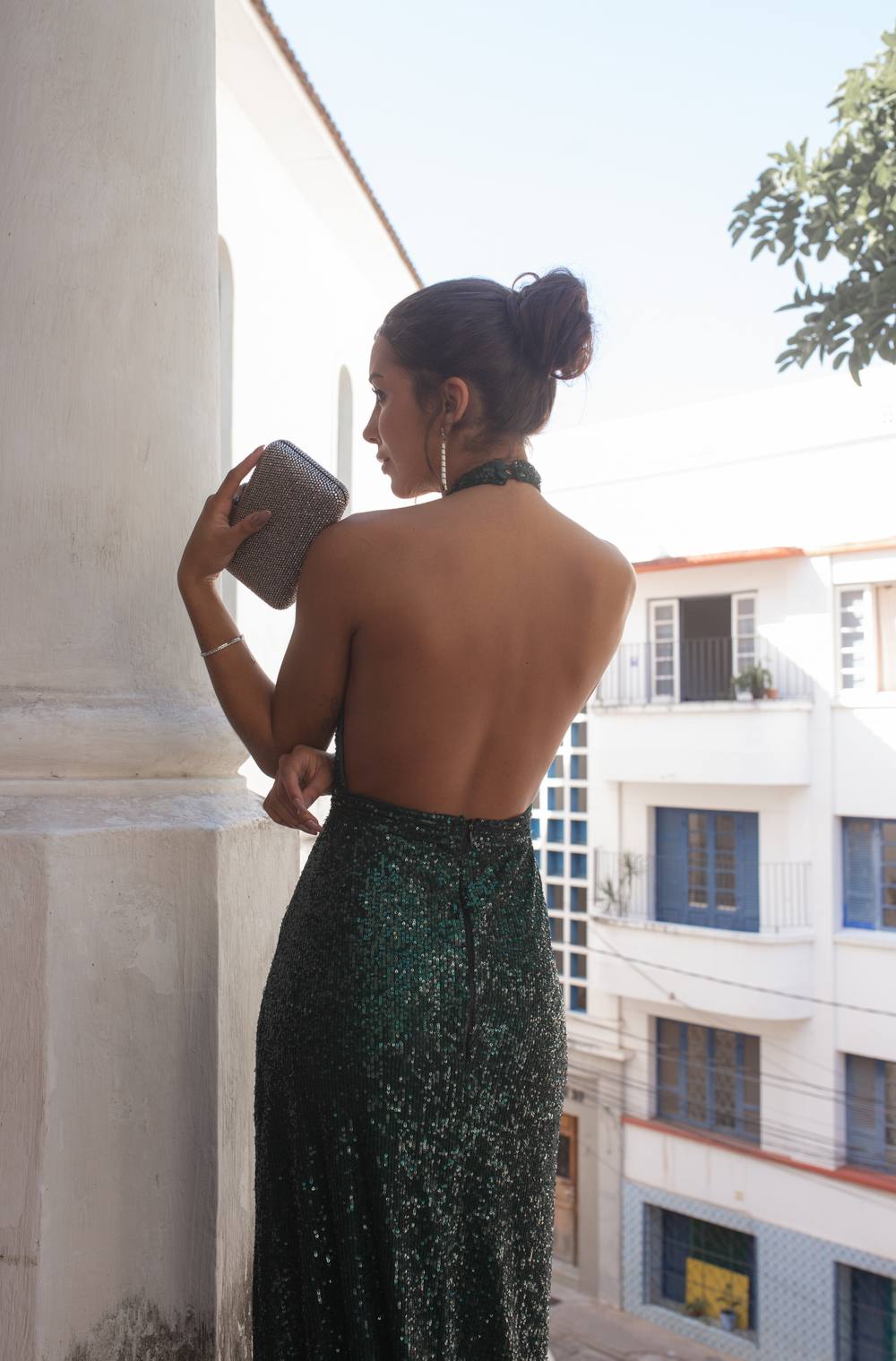 Vestido longo verde escuro com brilho de paetês, decote frente única com costas nuas e caimento ajustado ao corpo.