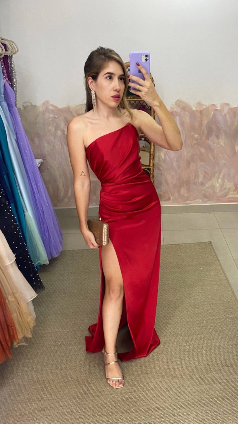 Vestido longo vermelho de cetim com decote de um ombro só, detalhes franzidos na cintura e fenda alta na saia.