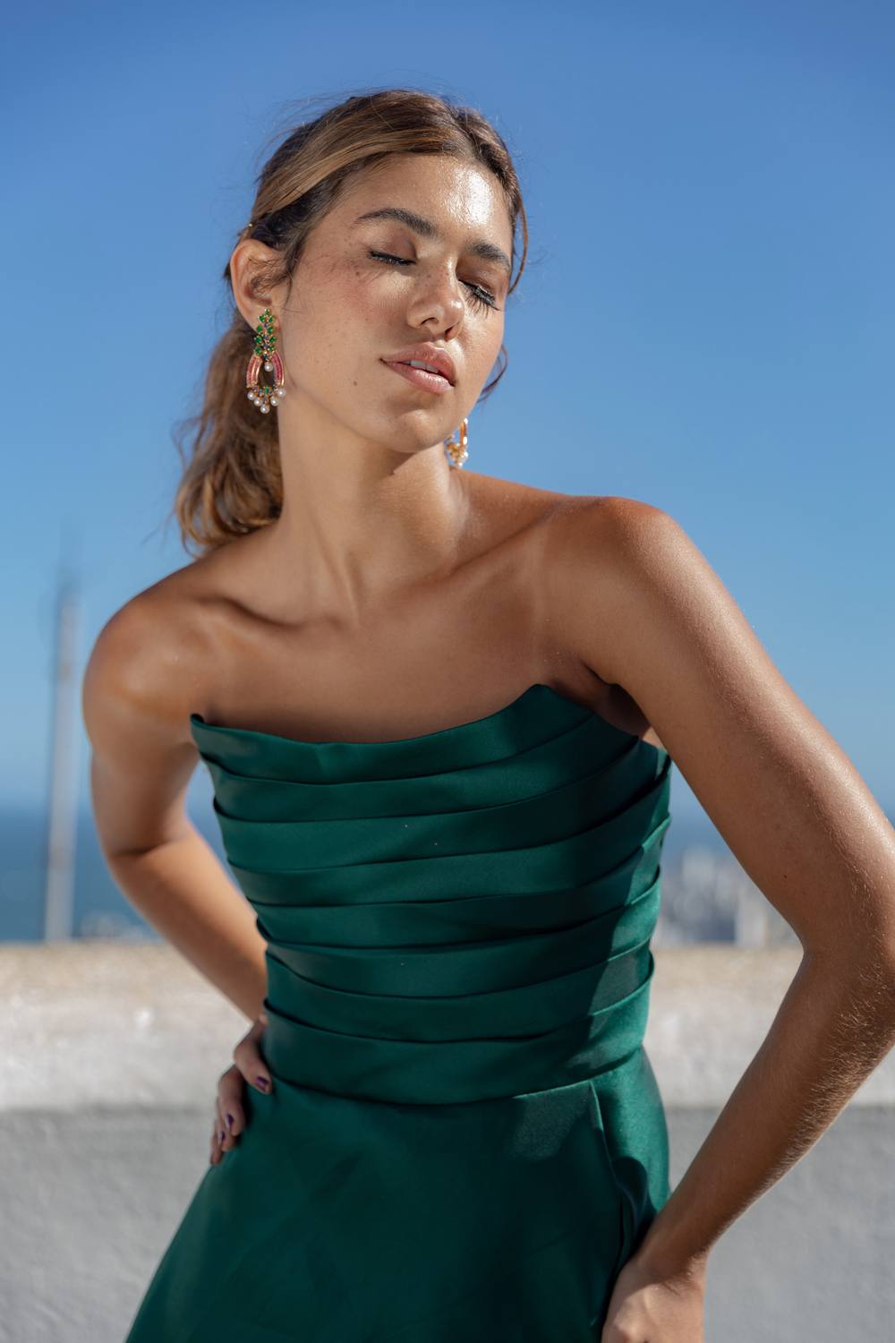 Vestido verde escuro tomara que caia em cetim com efeito plissado estruturado no busto.
