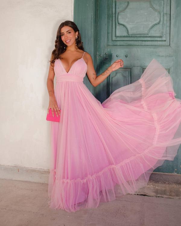 Vestido longo rosa de tule com brilho, decote V, alças finas e saia fluida com babado na barra.