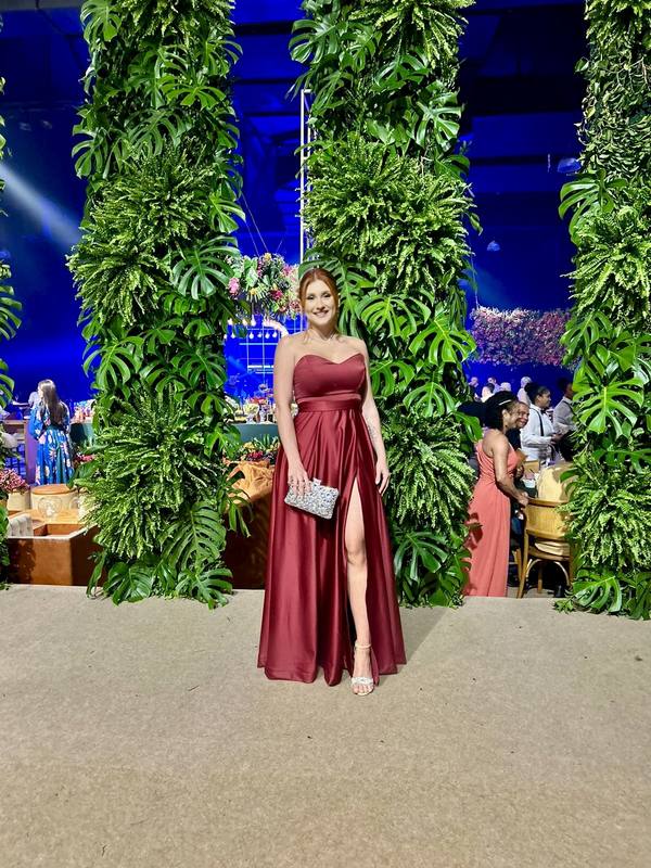 Vestido longo marsala em cetim, modelo tomara que caia, com fenda na saia e caimento evasê.