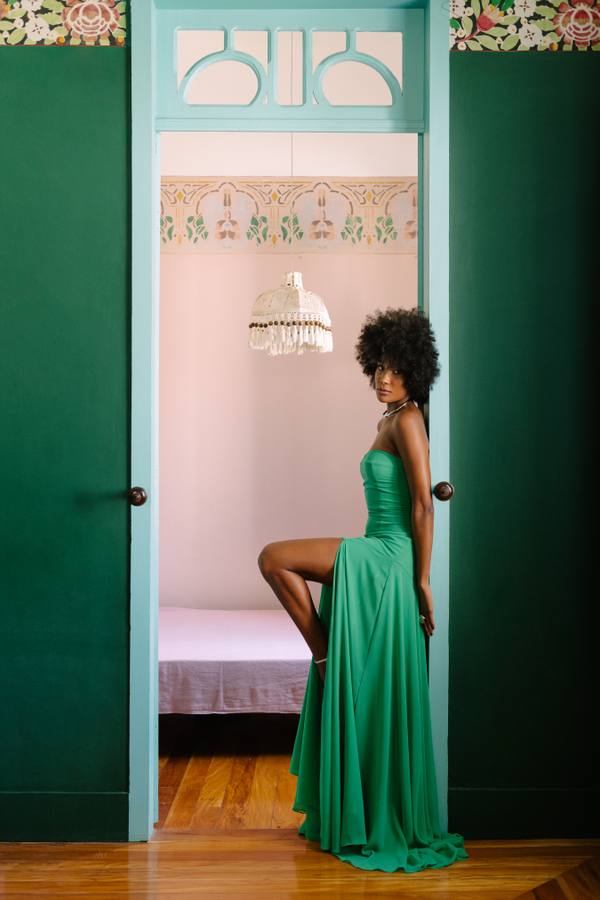 Vestido longo verde de tecido leve, tomara que caia, com saia fluida e fenda lateral.