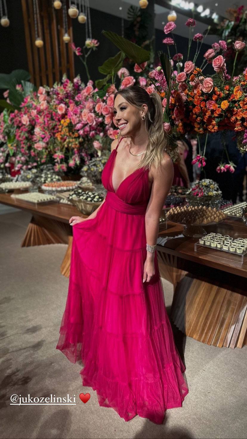 Vestido longo fúcsia de tule plissado, com alças finas, decote V e saia fluida em camadas.