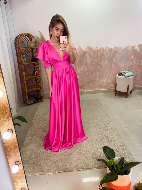 Vestido longo fúcsia de cetim com decote V, mangas esvoaçantes e saia fluida.
