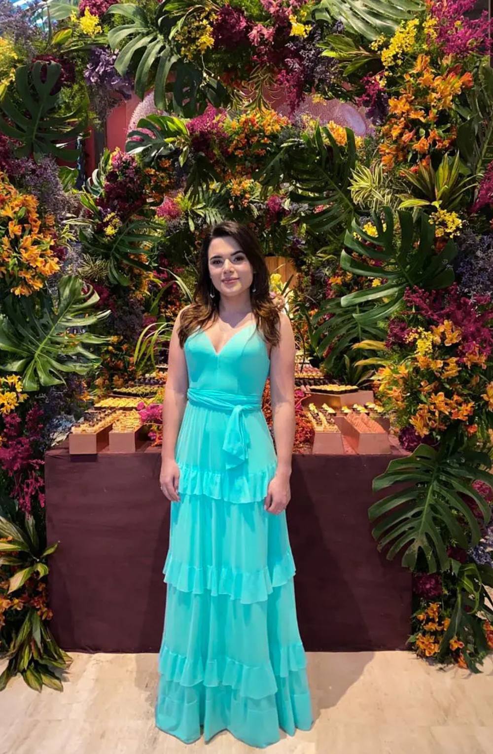 Vestido longo azul tiffany de alça fina, decote V, faixa na cintura e saia fluida com camadas de babados.