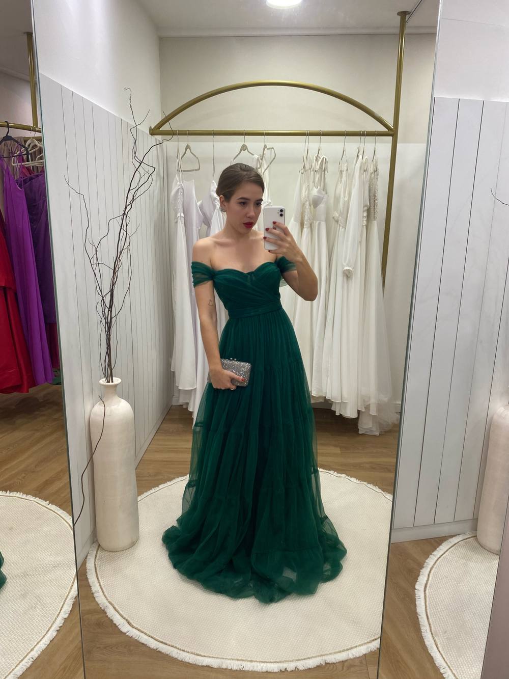 Vestido longo verde de tule, decote tomara que caia com mangas caídas e saia fluida.