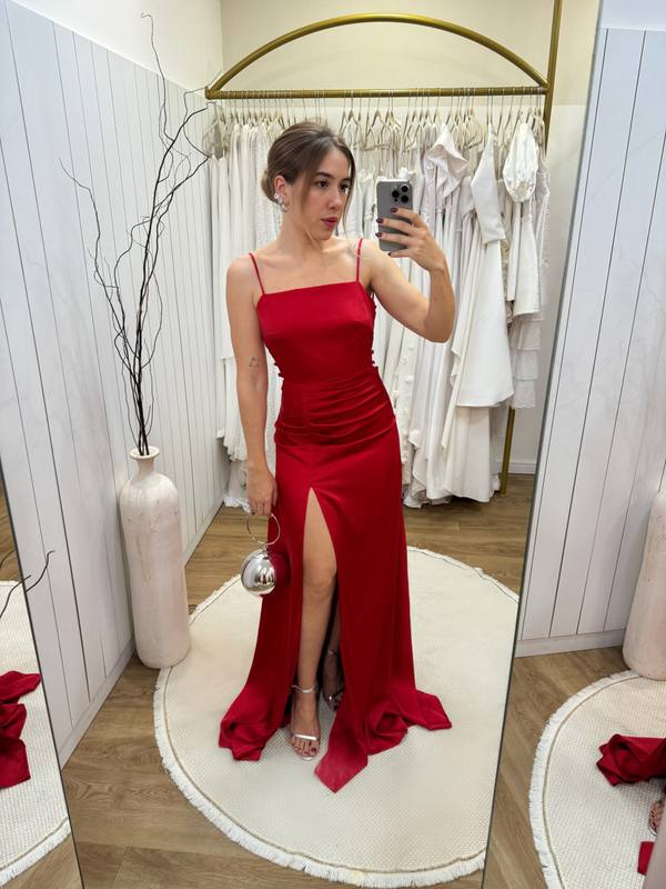 Vestido longo vermelho em cetim, com alças finas, fenda frontal e detalhe drapeado na cintura.