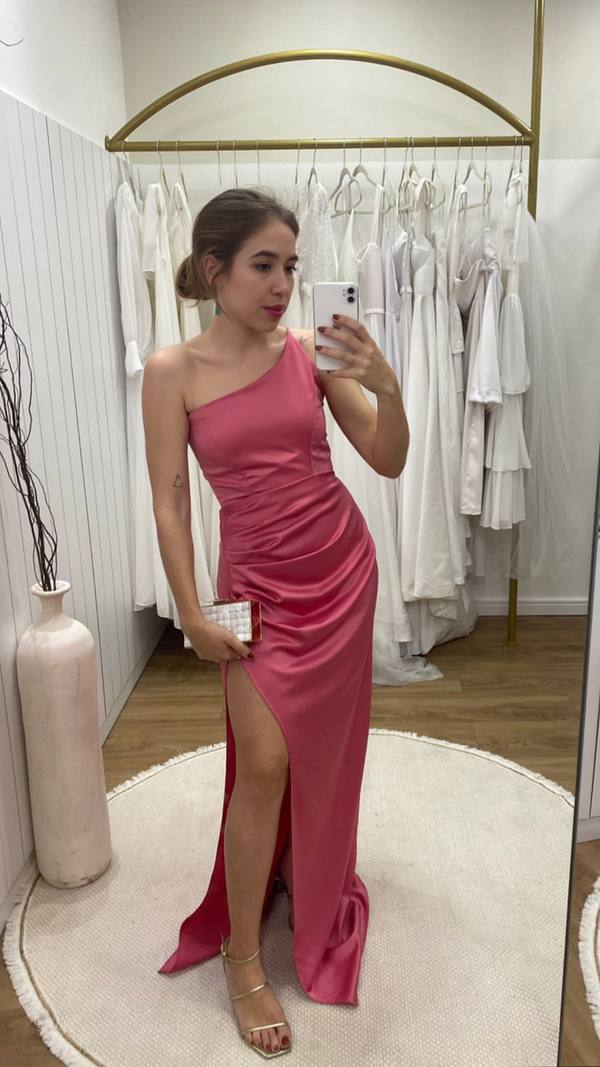 Vestido longo rosa de cetim, com decote de um ombro, drapeado na cintura e fenda profunda.