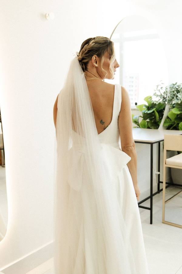 Vestido de noiva branco com costas em V, laço estruturado e véu