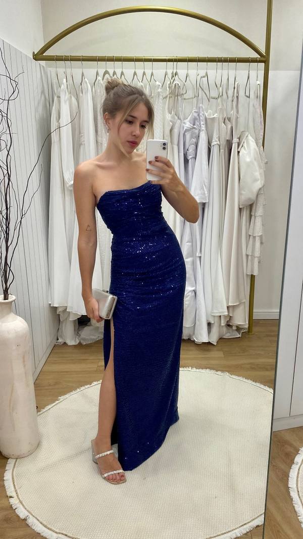 Vestido longo azul escuro de paetês, decote tomara que caia, caimento reto e fenda lateral.