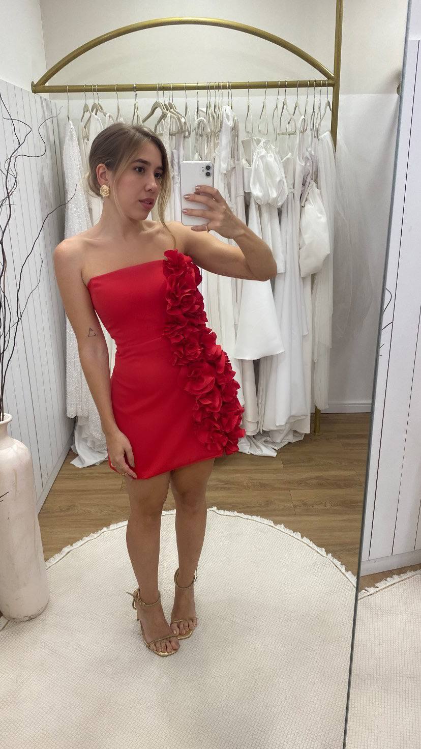 Vestido curto vermelho tomara que caia, caimento justo e detalhe de aplicação de flores tridimensionais na lateral.