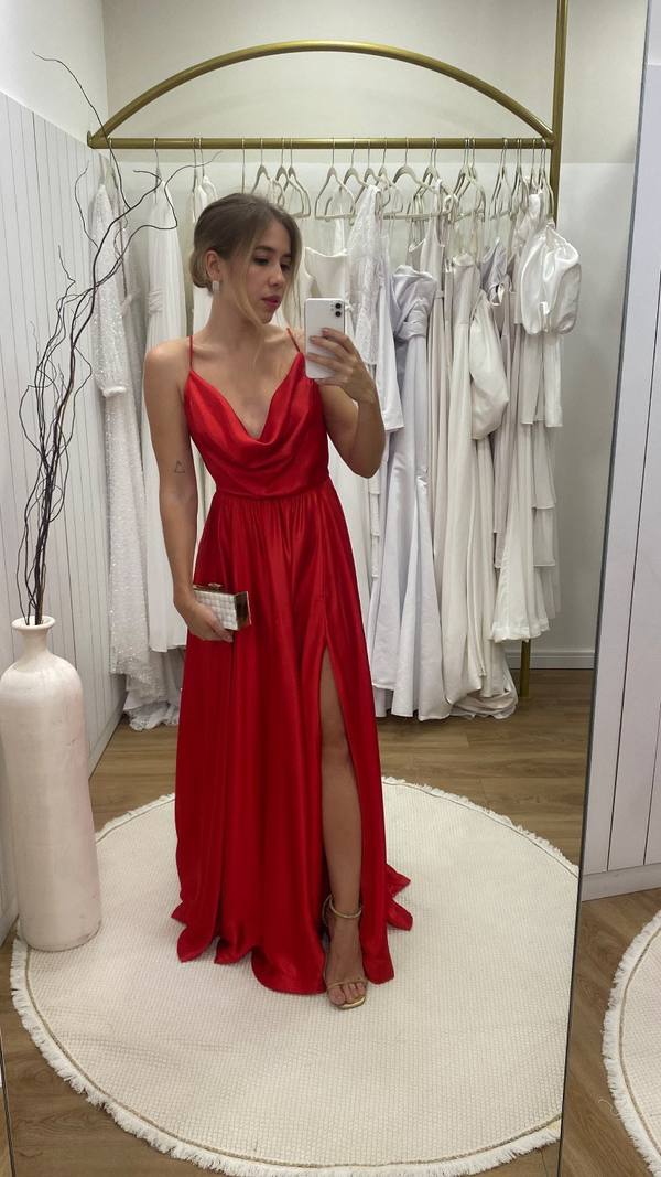 Vestido longo vermelho de cetim com alças finas, decote degagê e fenda lateral na saia.
