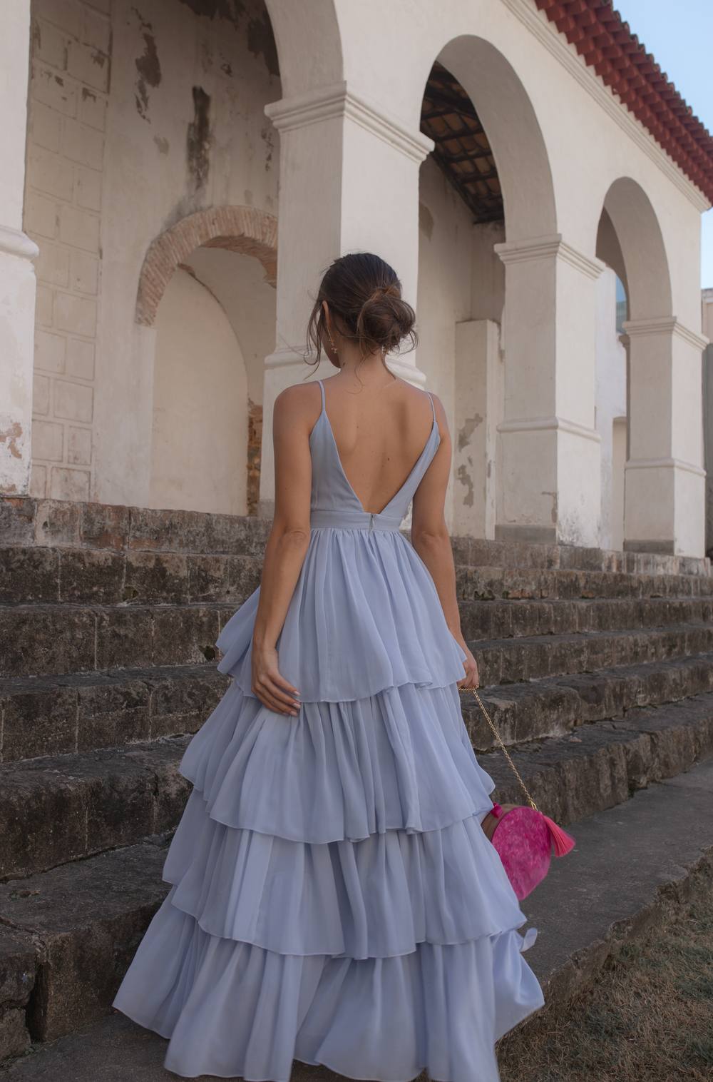 Vestido longo azul claro de chiffon com alças finas, decote profundo nas costas e saia fluida em camadas.