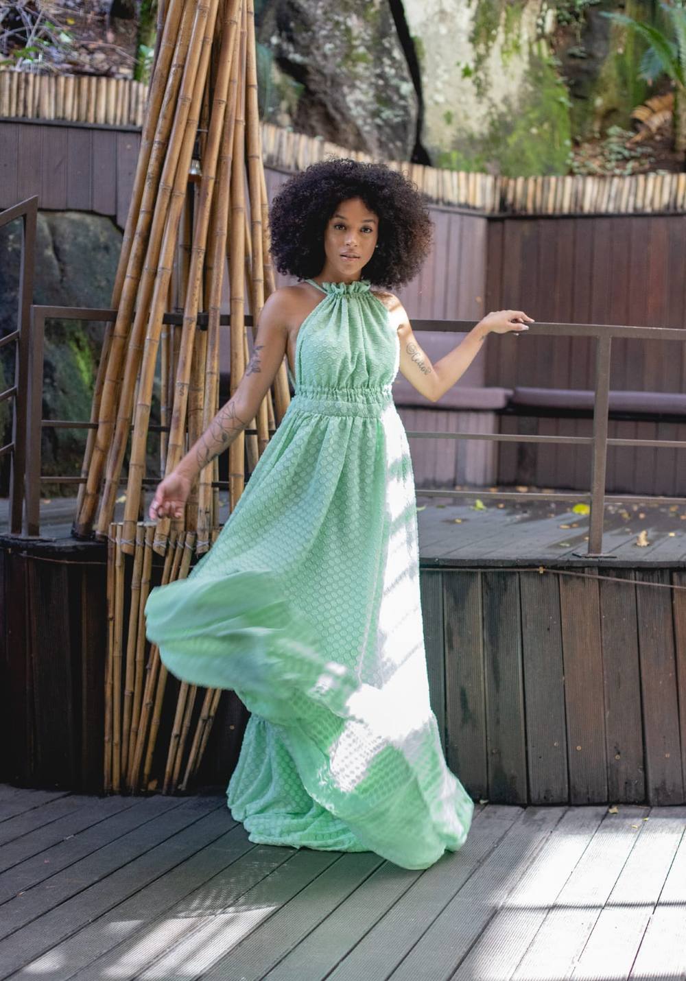 Vestido longo verde claro, modelo frente única com gola franzida e saia fluida e esvoaçante.