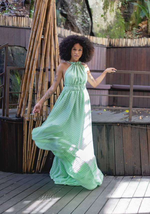 Vestido longo verde claro, modelo frente única com gola franzida e saia fluida e esvoaçante.