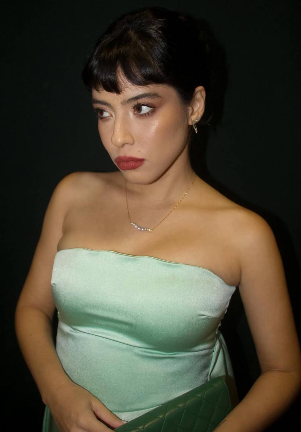 Vestido verde claro em tecido acetinado, com decote tomara que caia e caimento ajustado no busto.