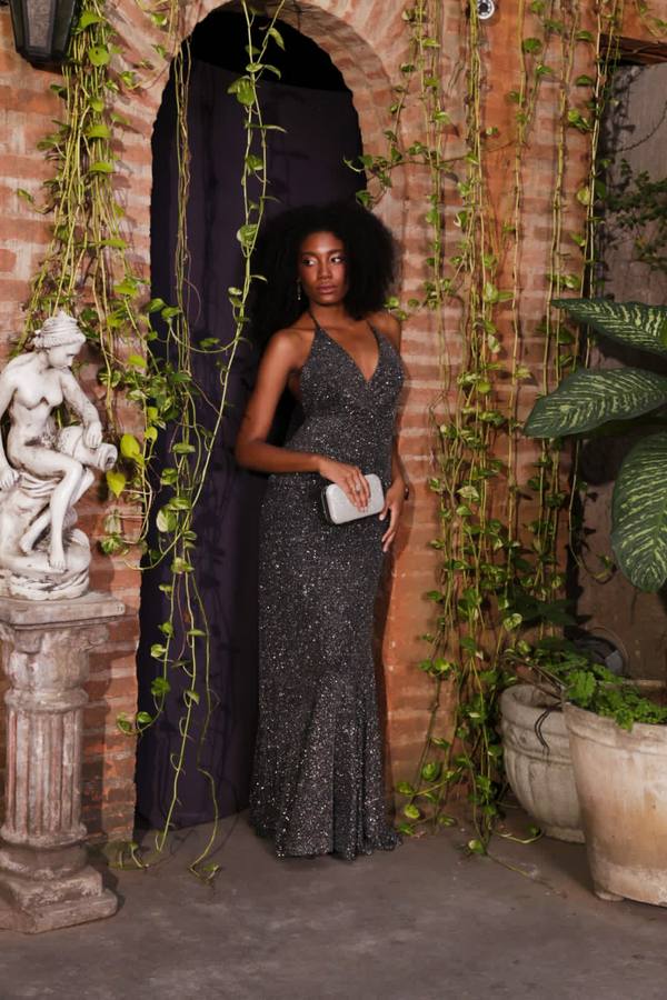 Vestido longo preto com brilho, decote frente única e modelagem sereia ajustada ao corpo.