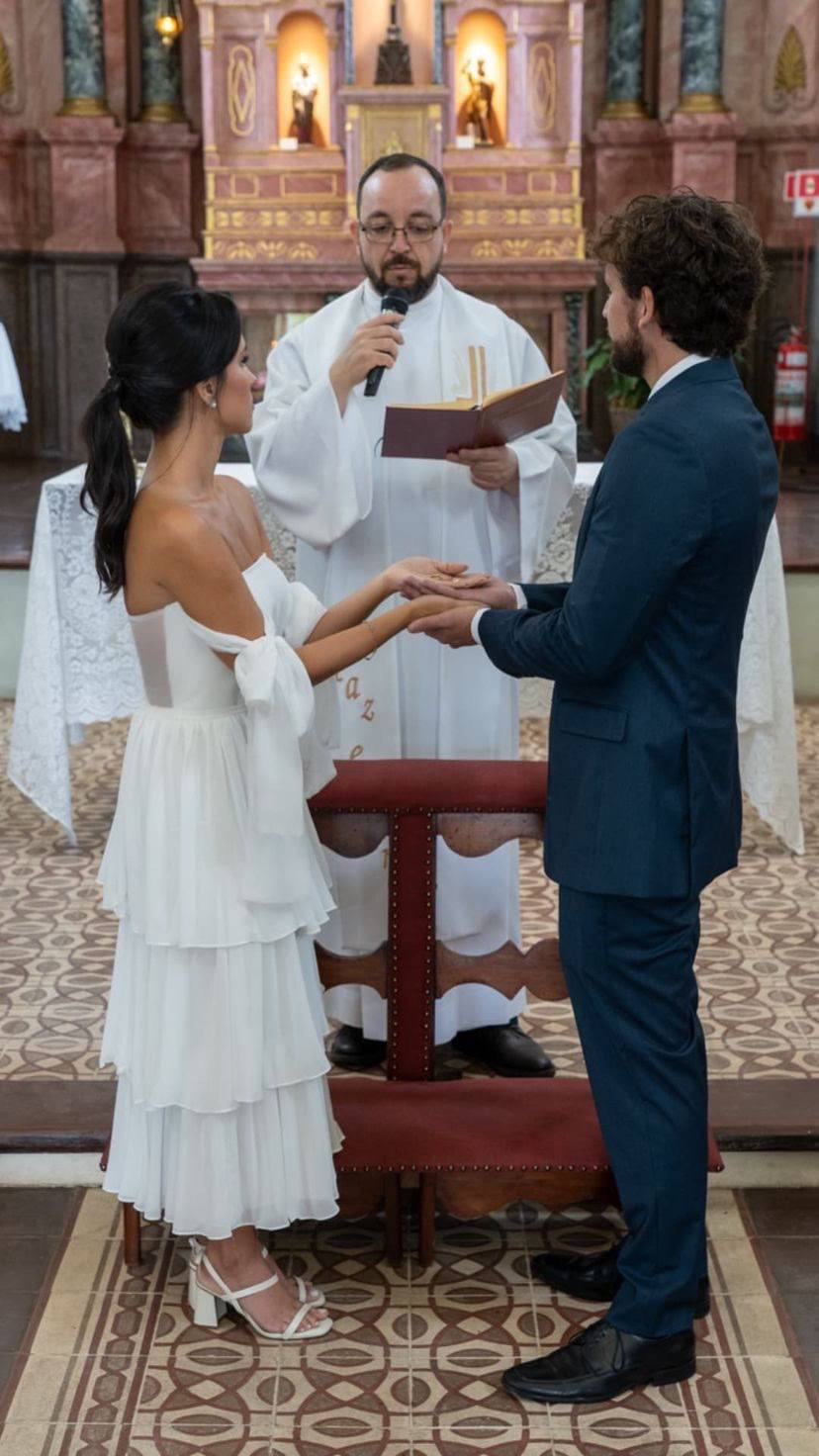 Vestido midi branco tomara que caia, saia fluida em camadas e detalhe de amarração nos braços.
