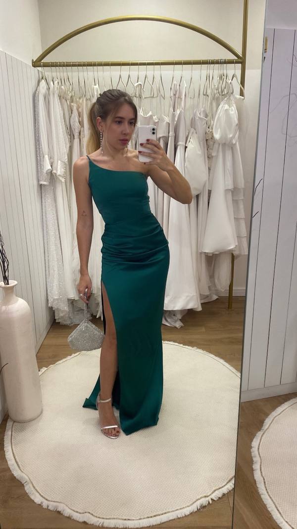 Vestido longo verde de cetim, decote de um ombro, caimento justo ao corpo e fenda lateral na saia.