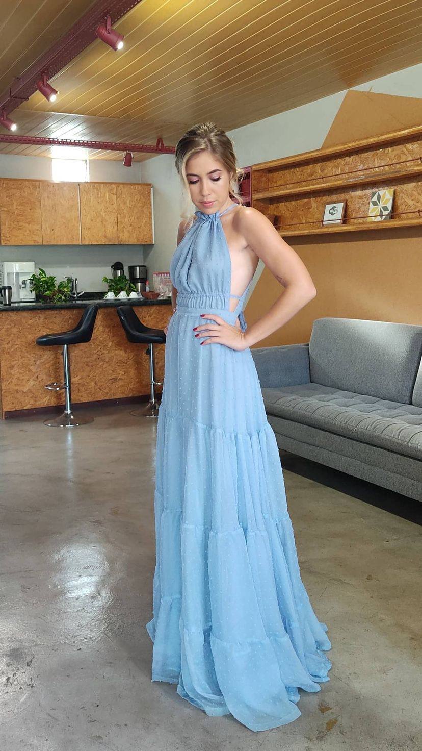 Vestido longo azul claro frente única, com saia fluida em camadas e costas abertas.