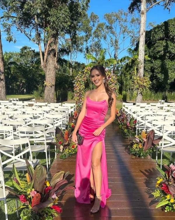 Vestido longo fúcsia de cetim, tomara que caia, com franzido no quadril e fenda lateral pronunciada.