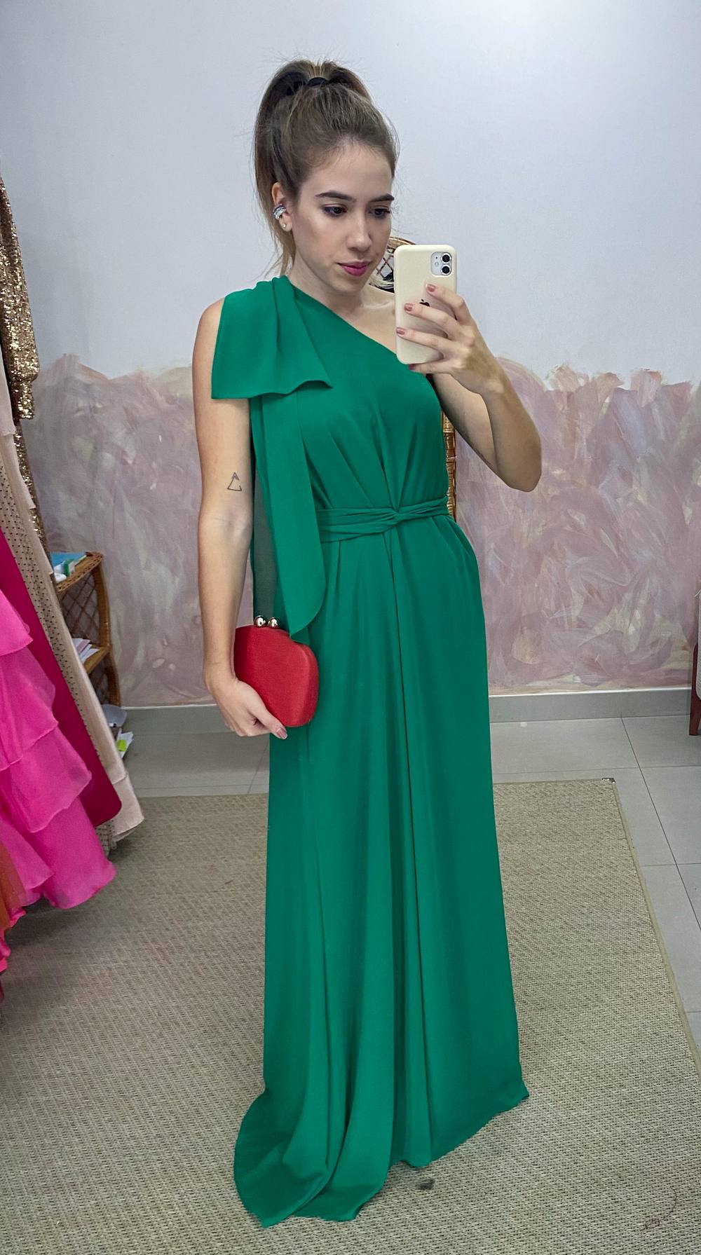 Vestido longo verde de um ombro só, em tecido fluido com detalhe de laço no ombro e amarração na cintura.