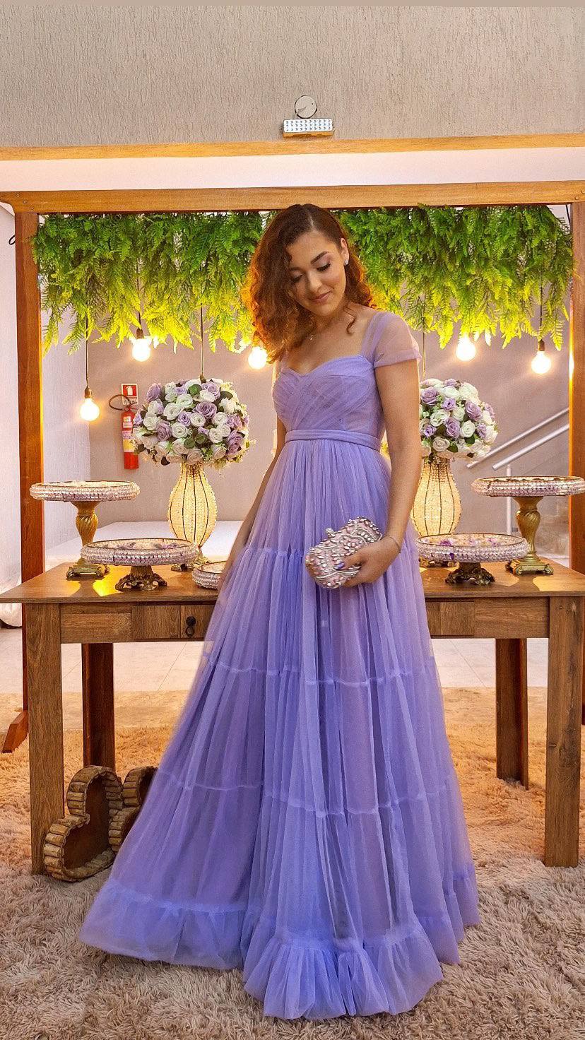 Vestido longo lilás em tule, com cintura marcada, saia fluida em camadas e corpete drapeado.