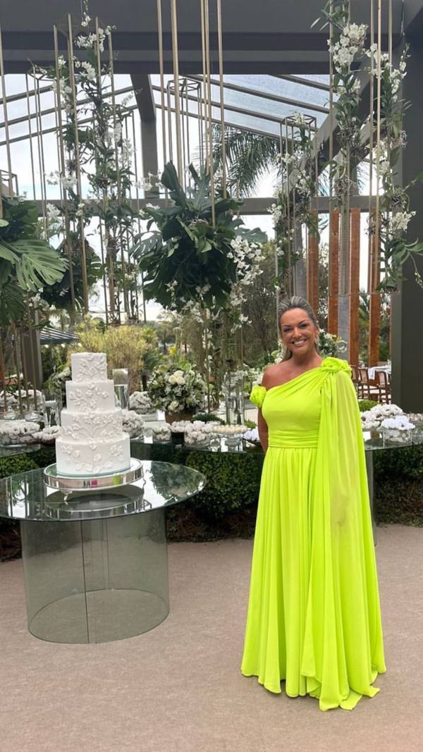 Vestido longo verde claro de um ombro só, caimento fluido com detalhe no ombro e cintura marcada.