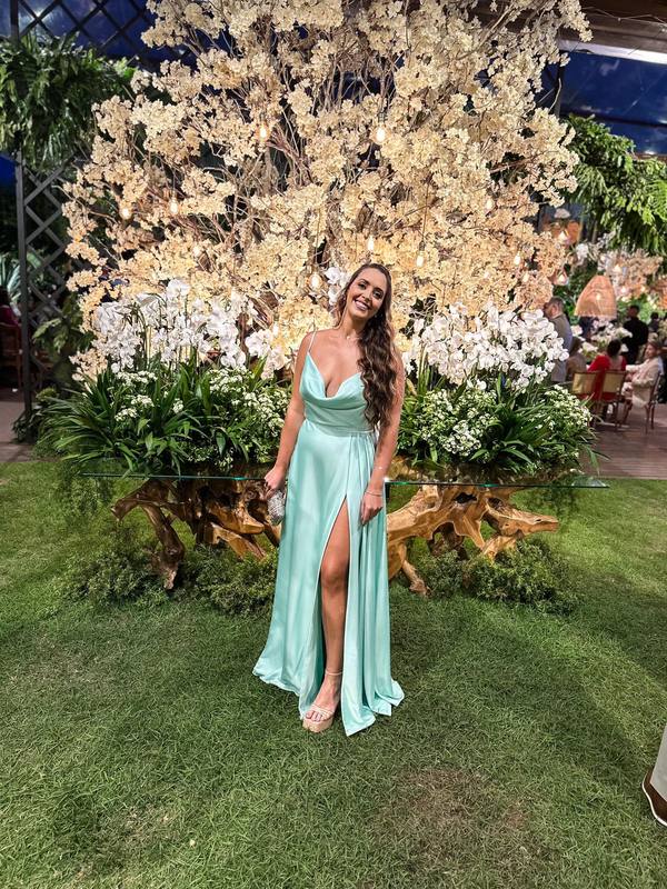 Vestido longo tiffany em cetim, com decote de alças finas, caimento fluido e fenda frontal destacada na saia.