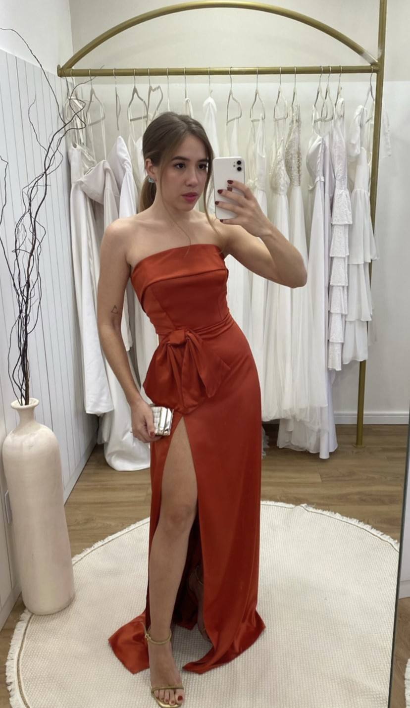 Vestido longo terracota de cetim, modelo tomara que caia com laço na cintura e fenda alta na saia.