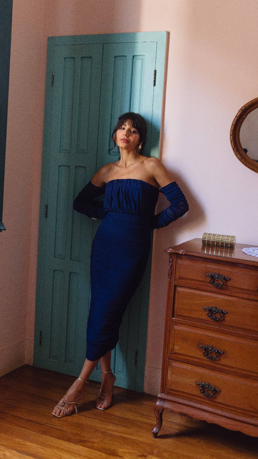 Vestido midi azul escuro ajustado ao corpo, modelo tomara que caia com mangas longas e tecido franzido.