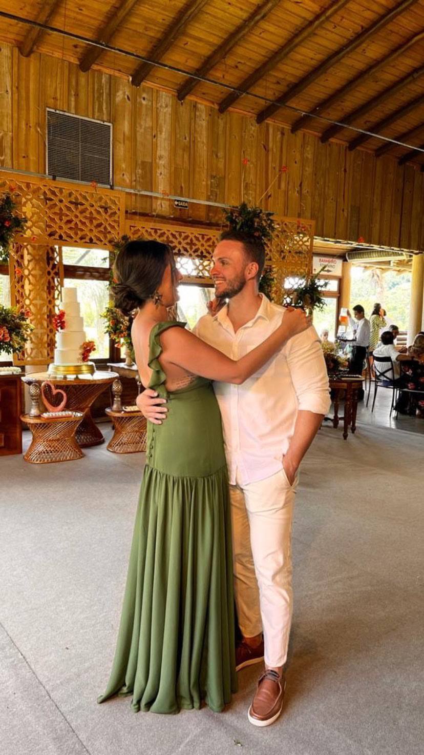 Vestido longo verde oliva de caimento fluido, com babados nas alças e costas abertas.
