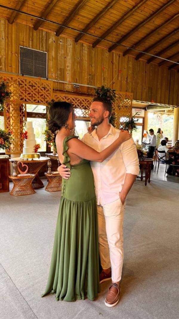 Vestido longo verde oliva de caimento fluido, com babados nas alças e costas abertas.