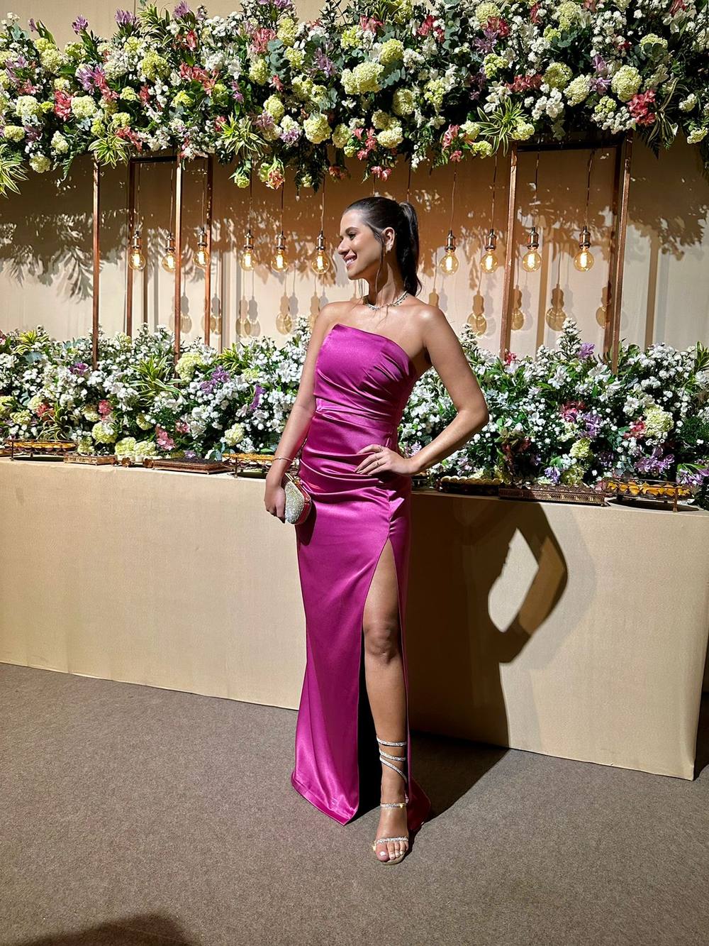 Vestido longo fúcsia tomara que caia em cetim com drapeado e fenda lateral.