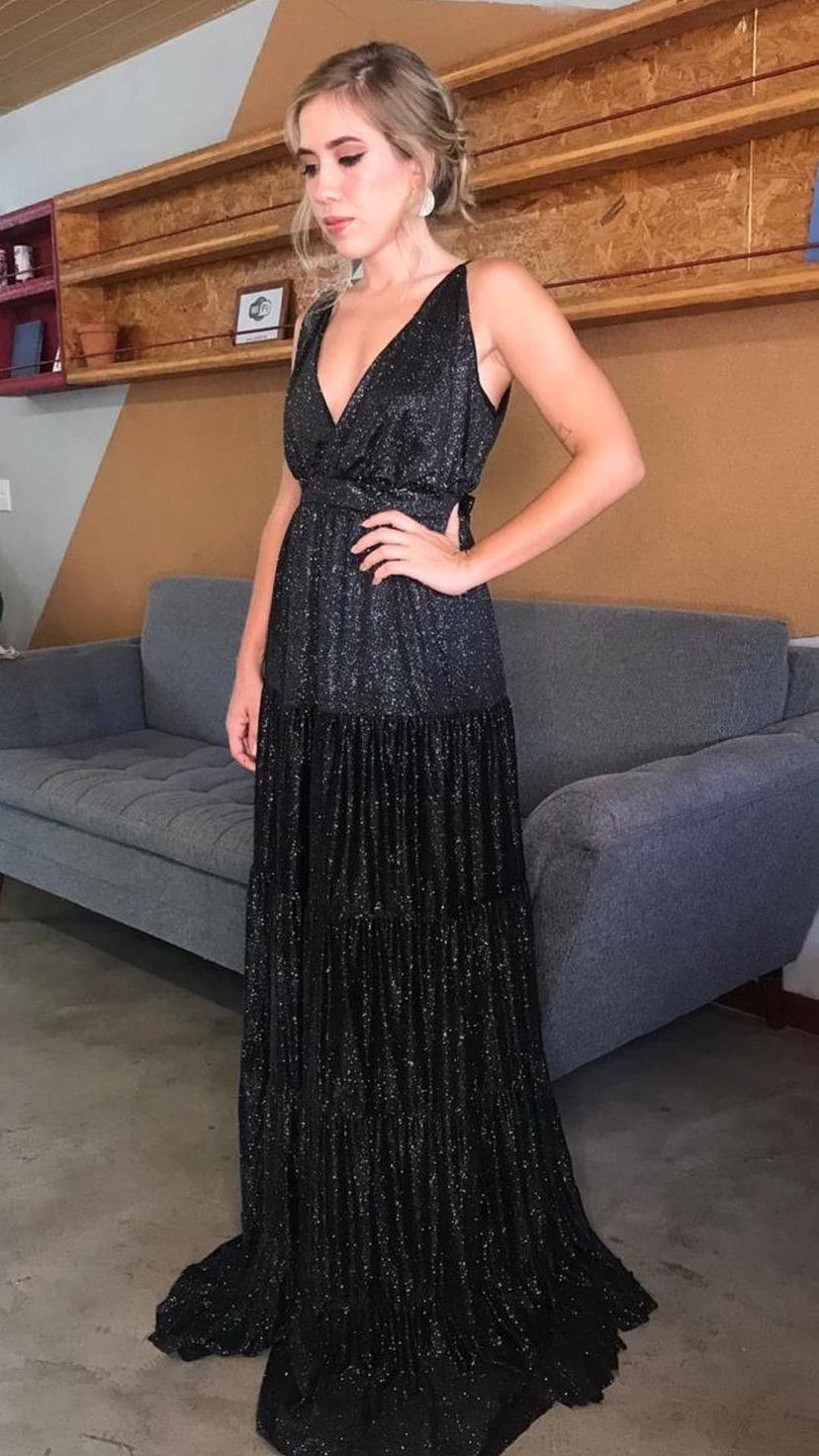 Vestido longo preto com brilho, decote V profundo, alças e saia fluida em camadas.