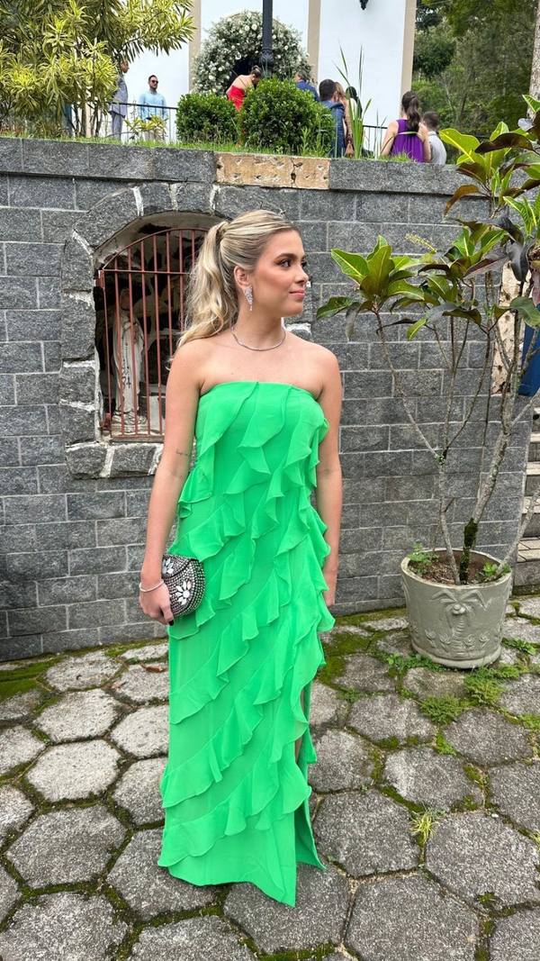Vestido longo verde de modelo tomara que caia, com camadas de babados ao longo do comprimento e caimento fluido.