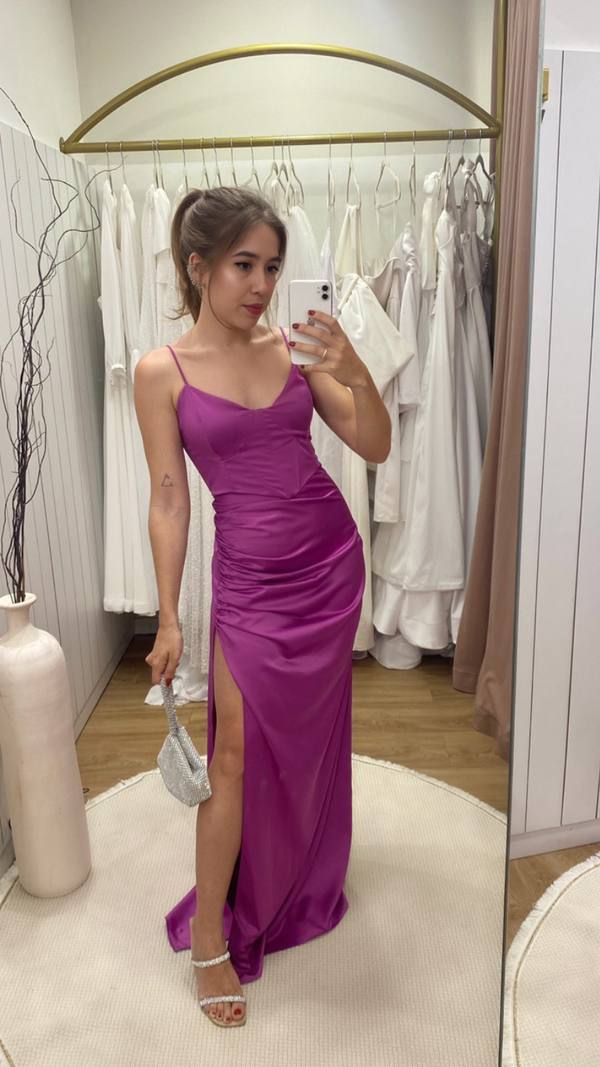 Vestido longo fúcsia de cetim com alças finas, drapeado no quadril e fenda lateral.