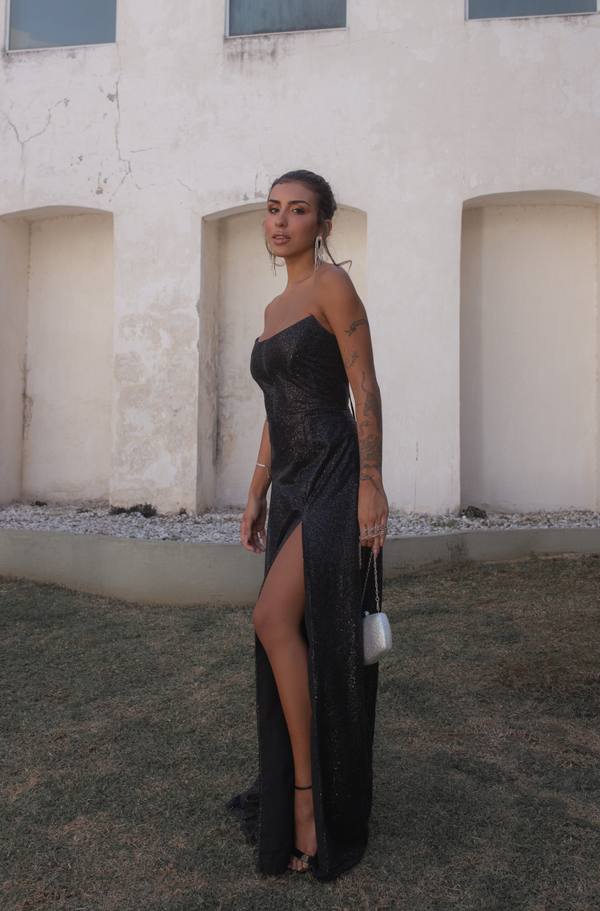 Vestido longo preto com brilho, modelo tomara que caia, caimento reto e fenda frontal alta.
