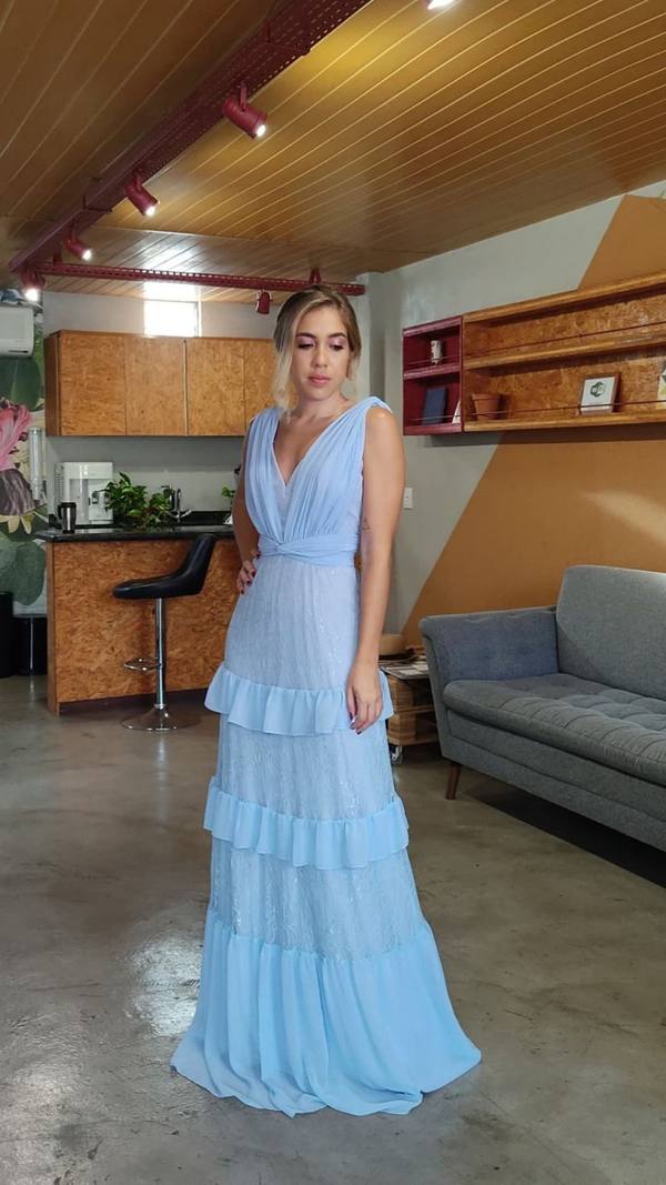 Vestido longo azul claro com decote V, corpete plissado e saia fluida com camadas de babados.