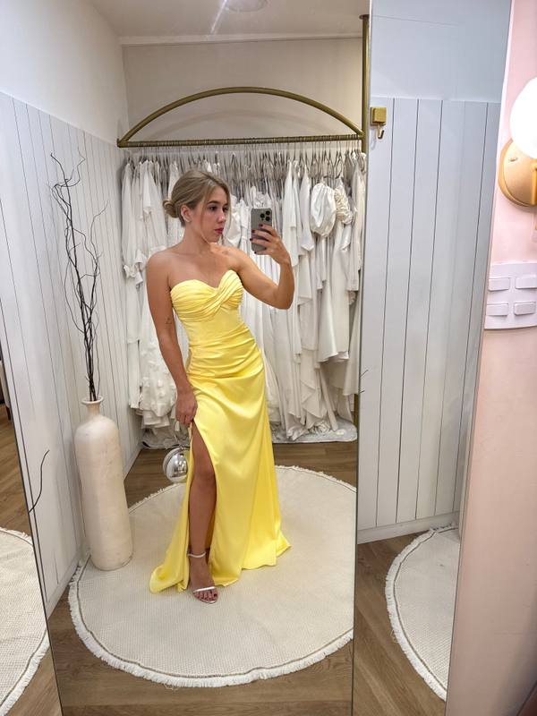 Vestido longo amarelo de cetim, tomara que caia, drapeado no busto e com fenda lateral na saia.