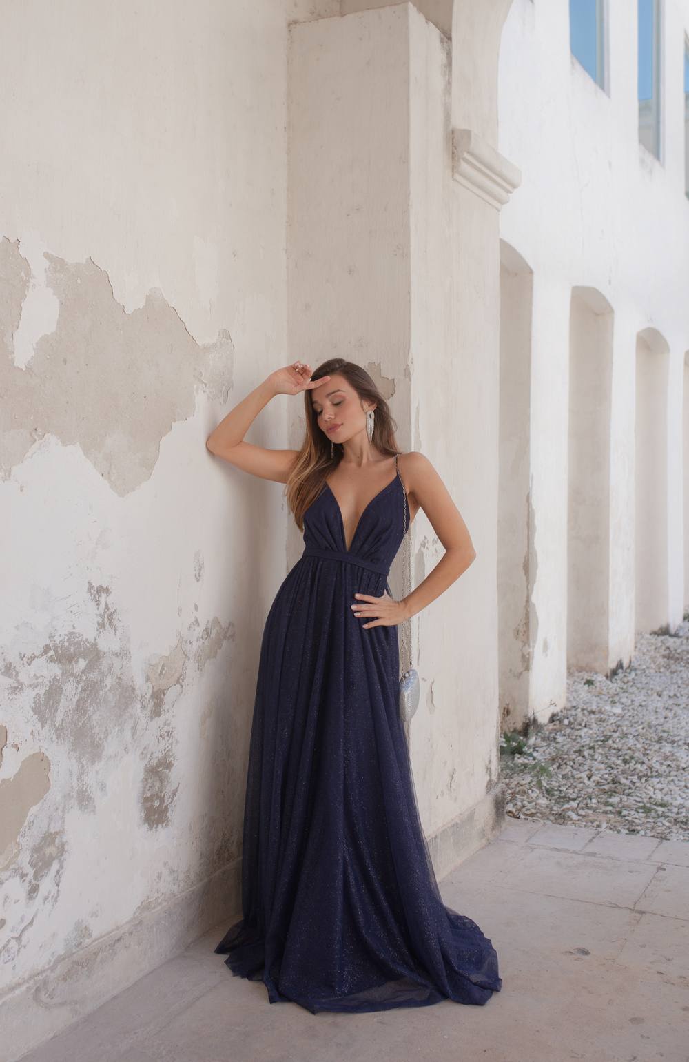 Vestido longo azul escuro com brilho, decote em V profundo, alças finas e saia fluida.