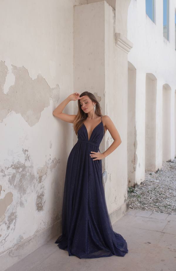 Vestido longo azul escuro com brilho, decote em V profundo, alças finas e saia fluida.