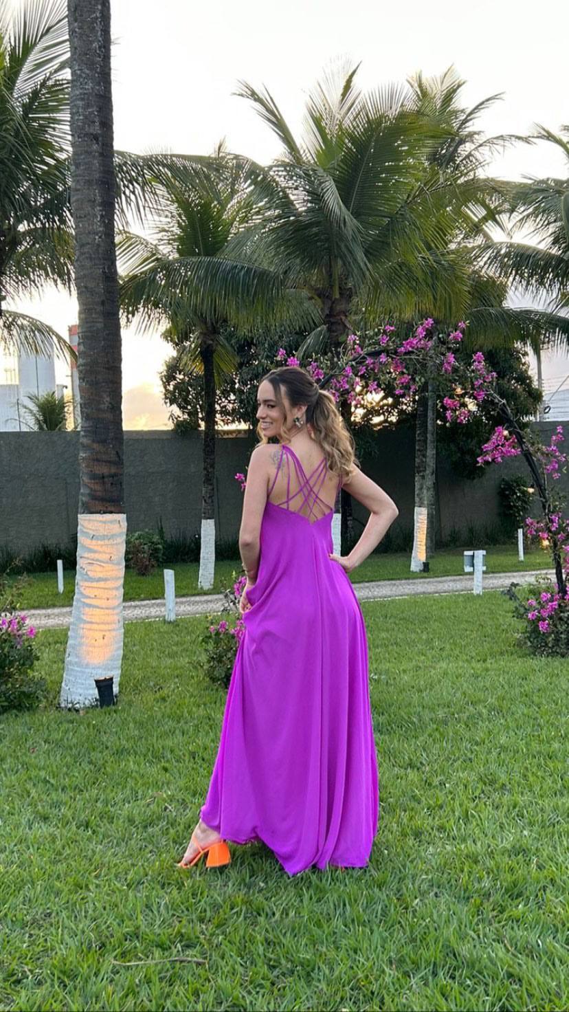 Vestido longo fúcsia fluido com tiras finas cruzadas nas costas e caimento leve.