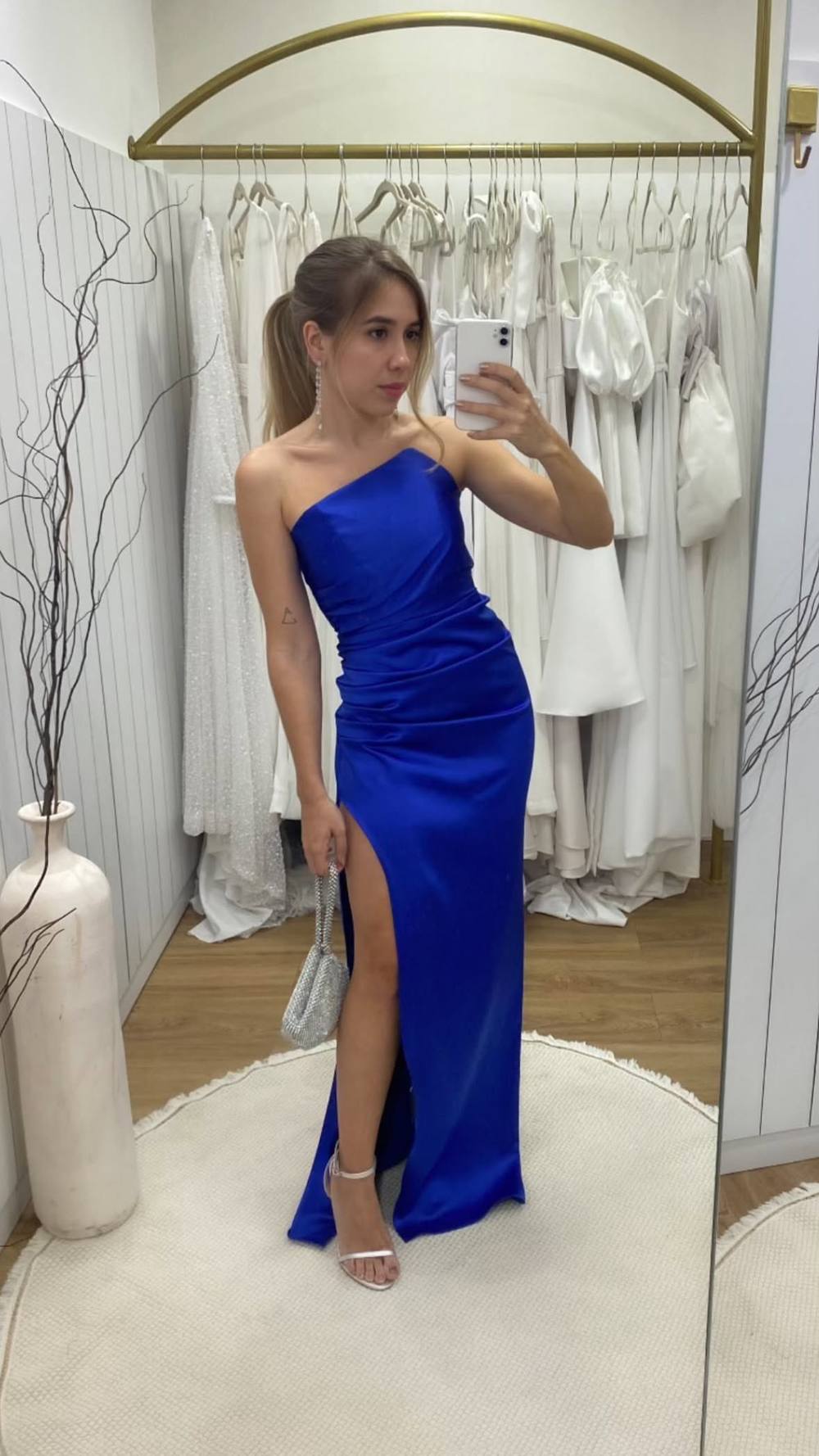 Vestido longo azul de cetim, decote tomara que caia com corte assimétrico, corpo drapeado e fenda alta na saia.